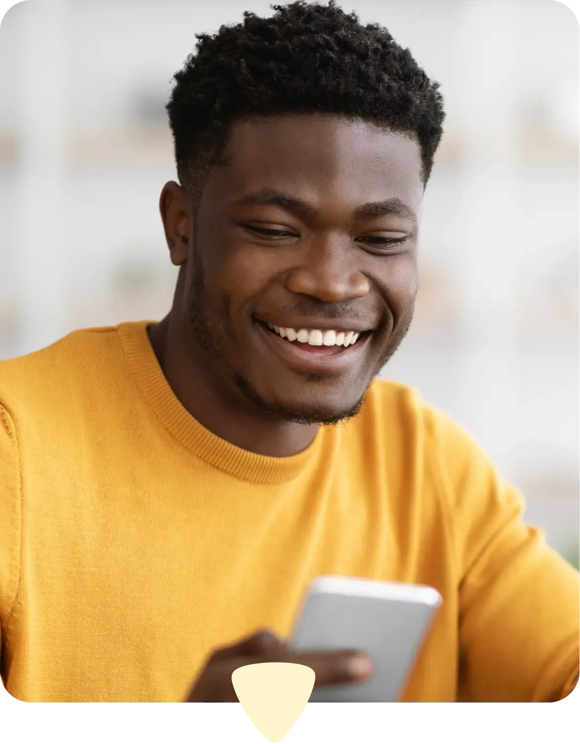 Man in yellow sweater using his phone