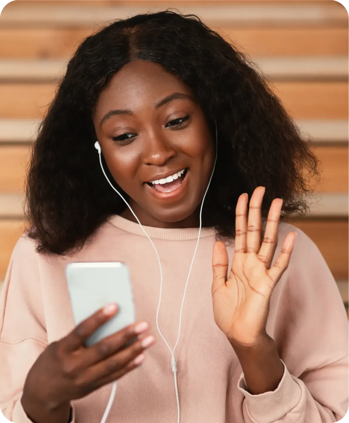 Woman waving while listening to a personalised SMS